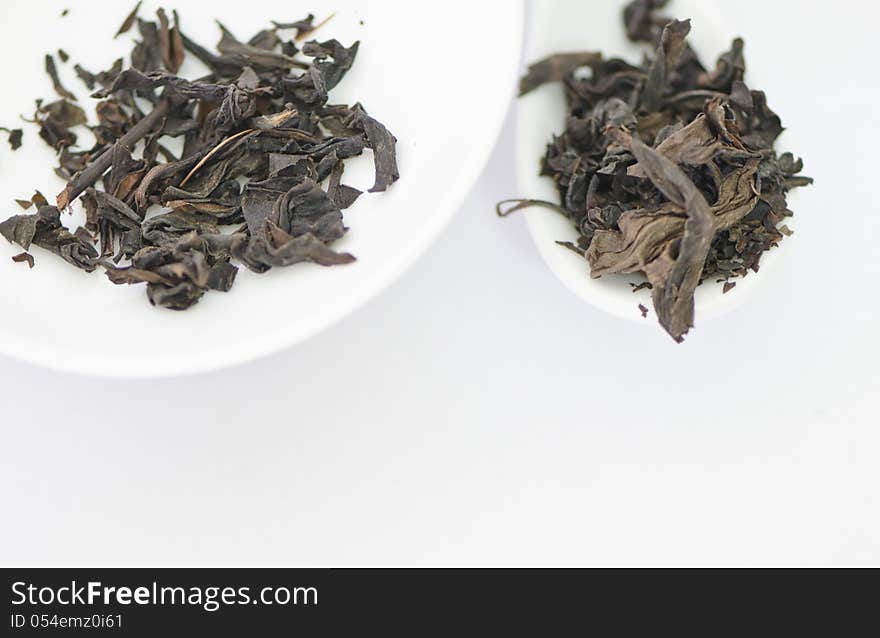 Dry tea leaves on a white background