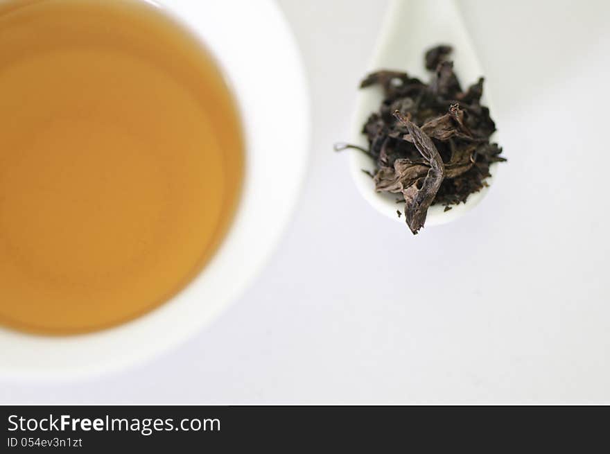 Cup of chinese tea with dry tea leaves isolated on white background