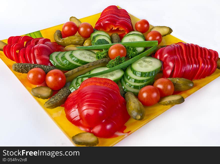 Artistically sliced vegetables on a plate isolated on white