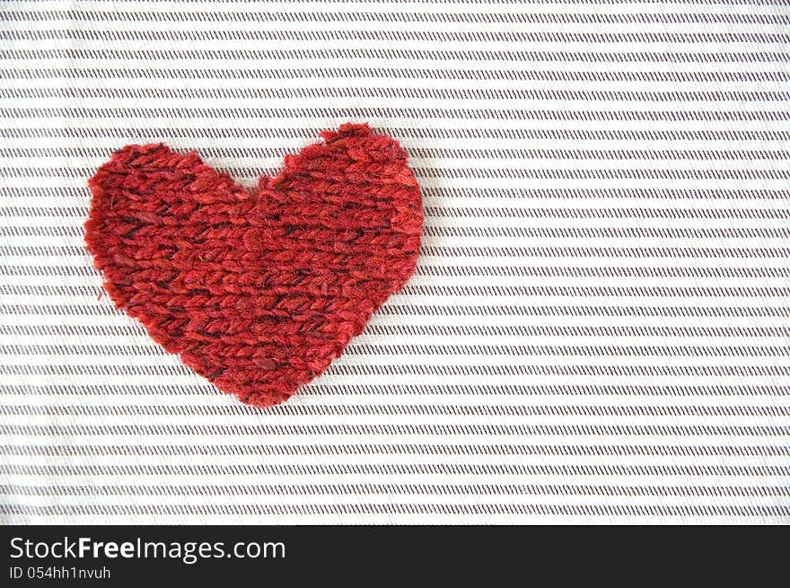 Red heart on striped fabric background