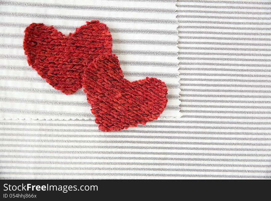 Two red hearts on striped white fabric. Two red hearts on striped white fabric