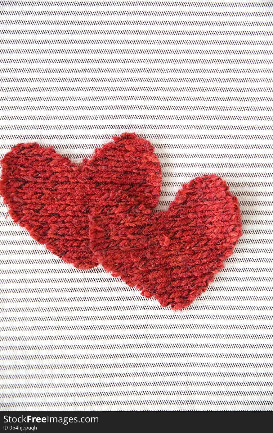 Two red hearts fabric on striped background. Two red hearts fabric on striped background