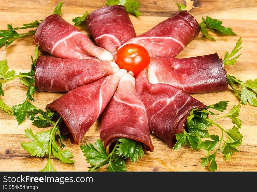 Slices of smoked prosciutto and herbs