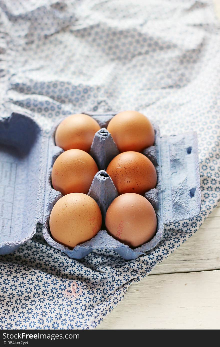 Blue box full with eggs on a white blue background. Blue box full with eggs on a white blue background