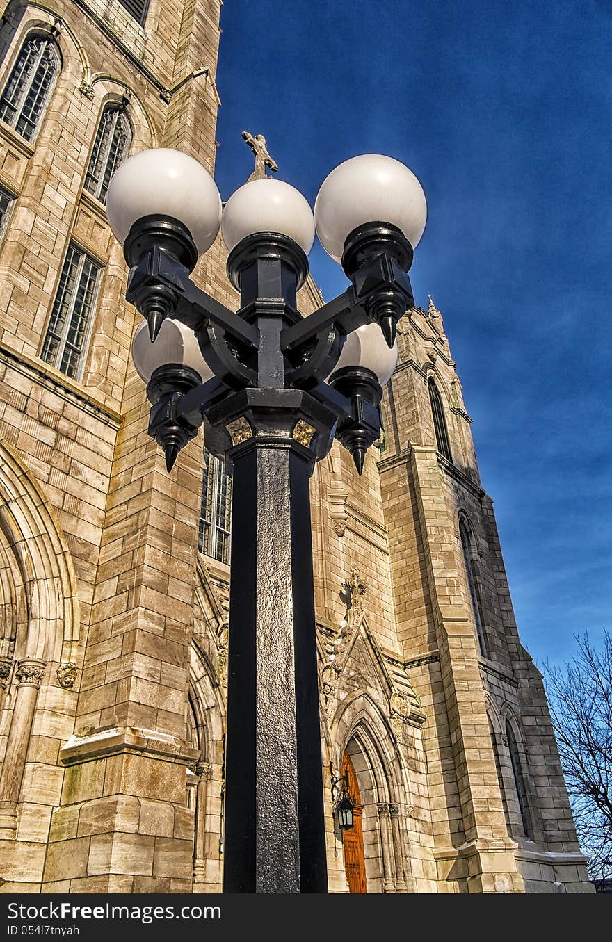 Lamp post in front of a church on a blue sky. Lamp post in front of a church on a blue sky