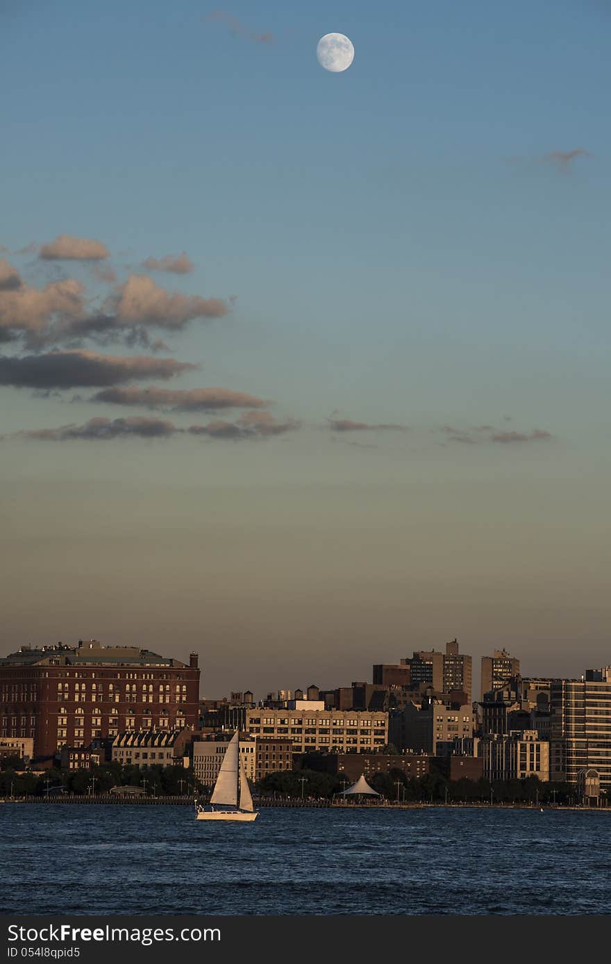 Moon over New York City and Hudson River with small Yacht