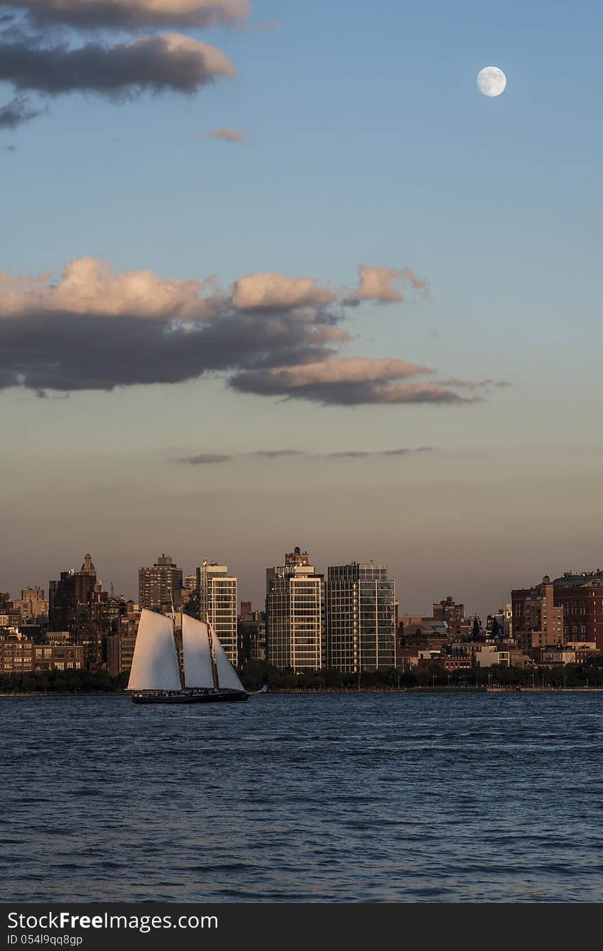 Moon over New York City and Hudson River with small Yacht