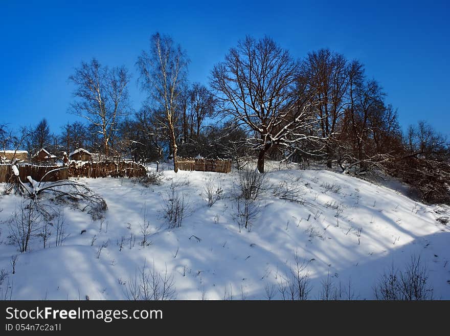 Winter landscape with sheds and wooden fences