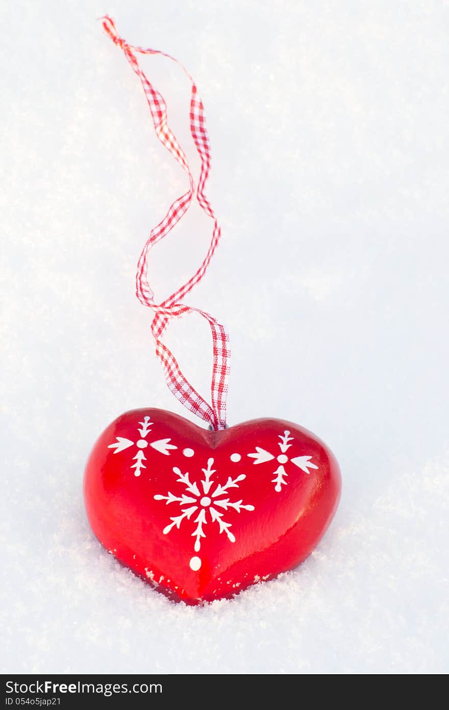 Wooden heart decoration on the snow outdoors one afternoon. Wooden heart decoration on the snow outdoors one afternoon