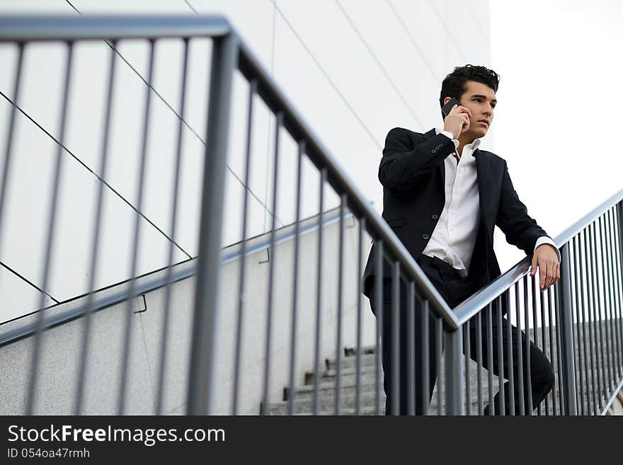 Portrait of a young businessman in an office building talking on the phone. Portrait of a young businessman in an office building talking on the phone