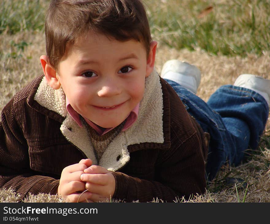 Happy little boy laying on the grass. Happy little boy laying on the grass