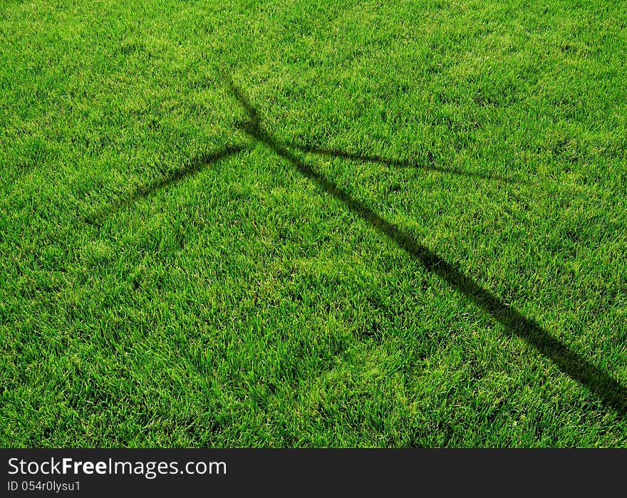 Wind Generator Turbine Shadow on the Grass - Green Renewable Energy