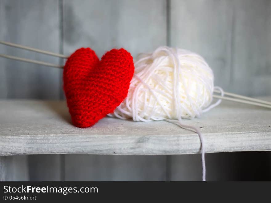 Photo of ball of wool and heart on wooden background