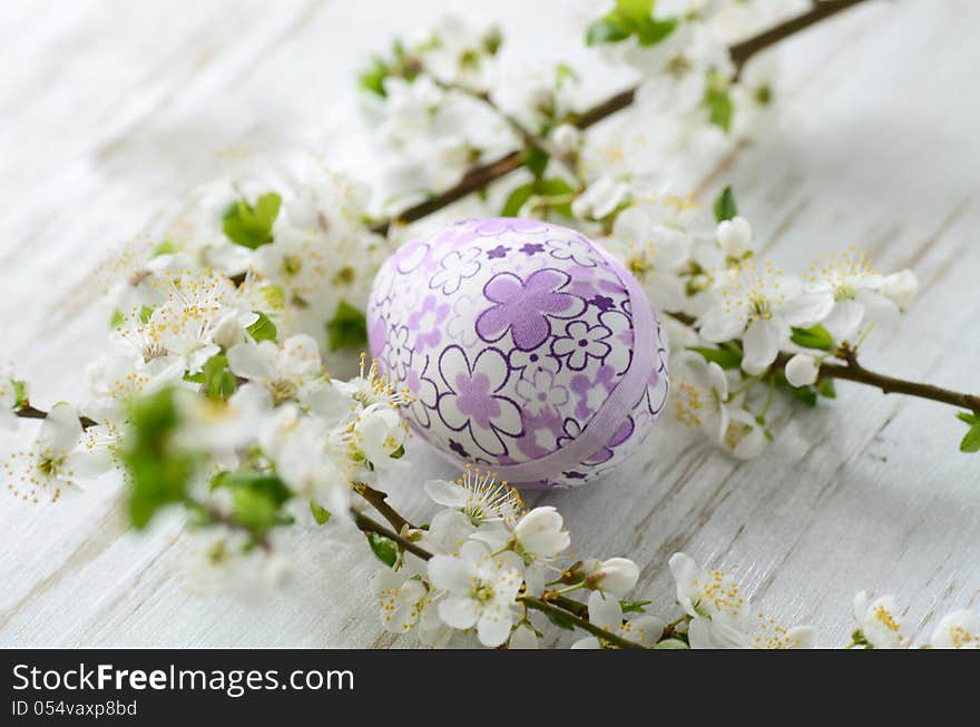 Easter eggs and branch with flowers on wooden background