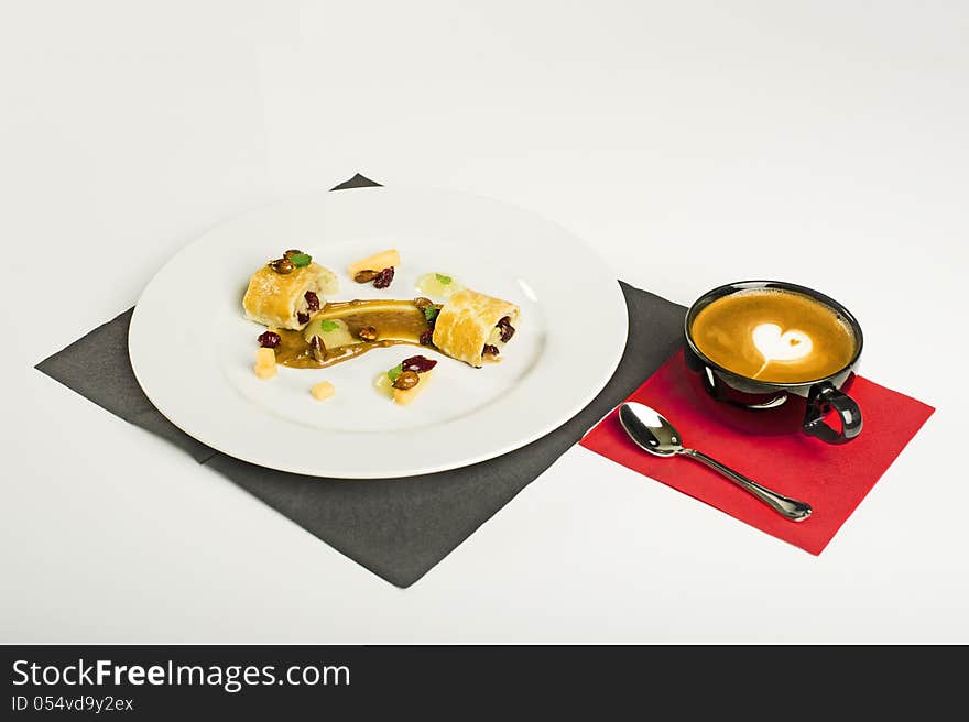 Plate with chocolate and coffee dessert with aldmond nuts and coffee on a white background. Plate with chocolate and coffee dessert with aldmond nuts and coffee on a white background