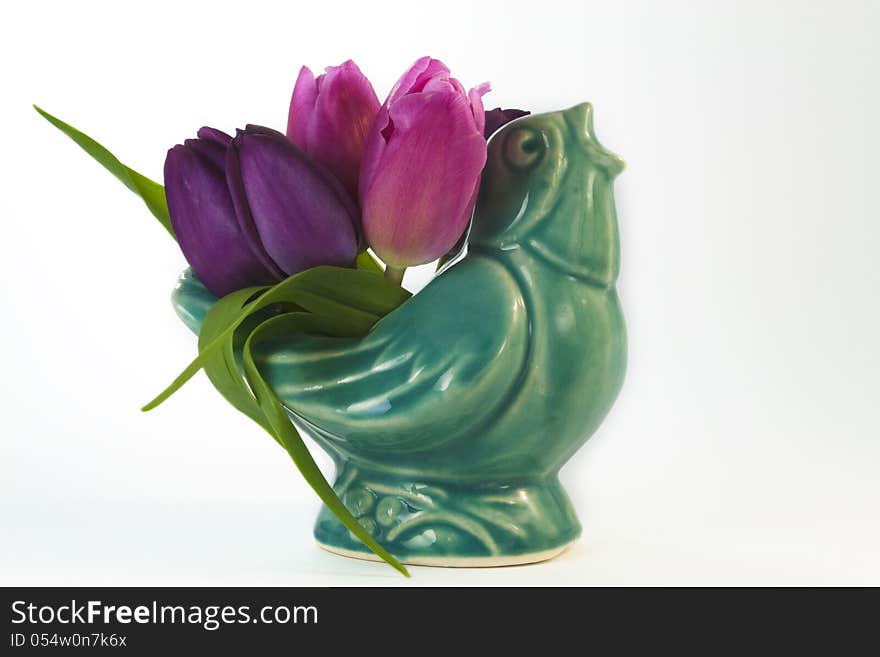 Antique ceramic blue bird with pink and purple tulips spring is in the air isolated on white background. Antique ceramic blue bird with pink and purple tulips spring is in the air isolated on white background