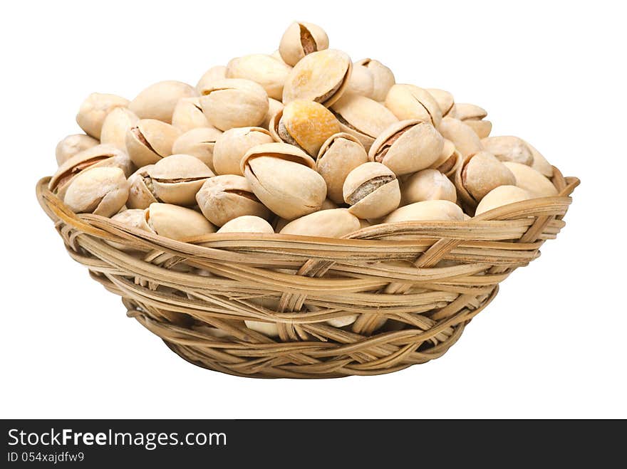 Pistachio nuts in a wicker plate, isolated on a white background