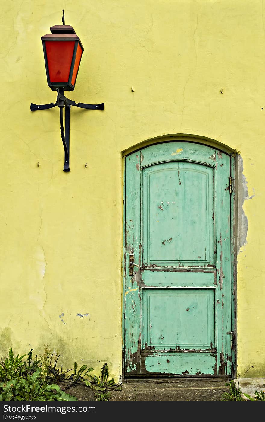 Old yellow wall with green door