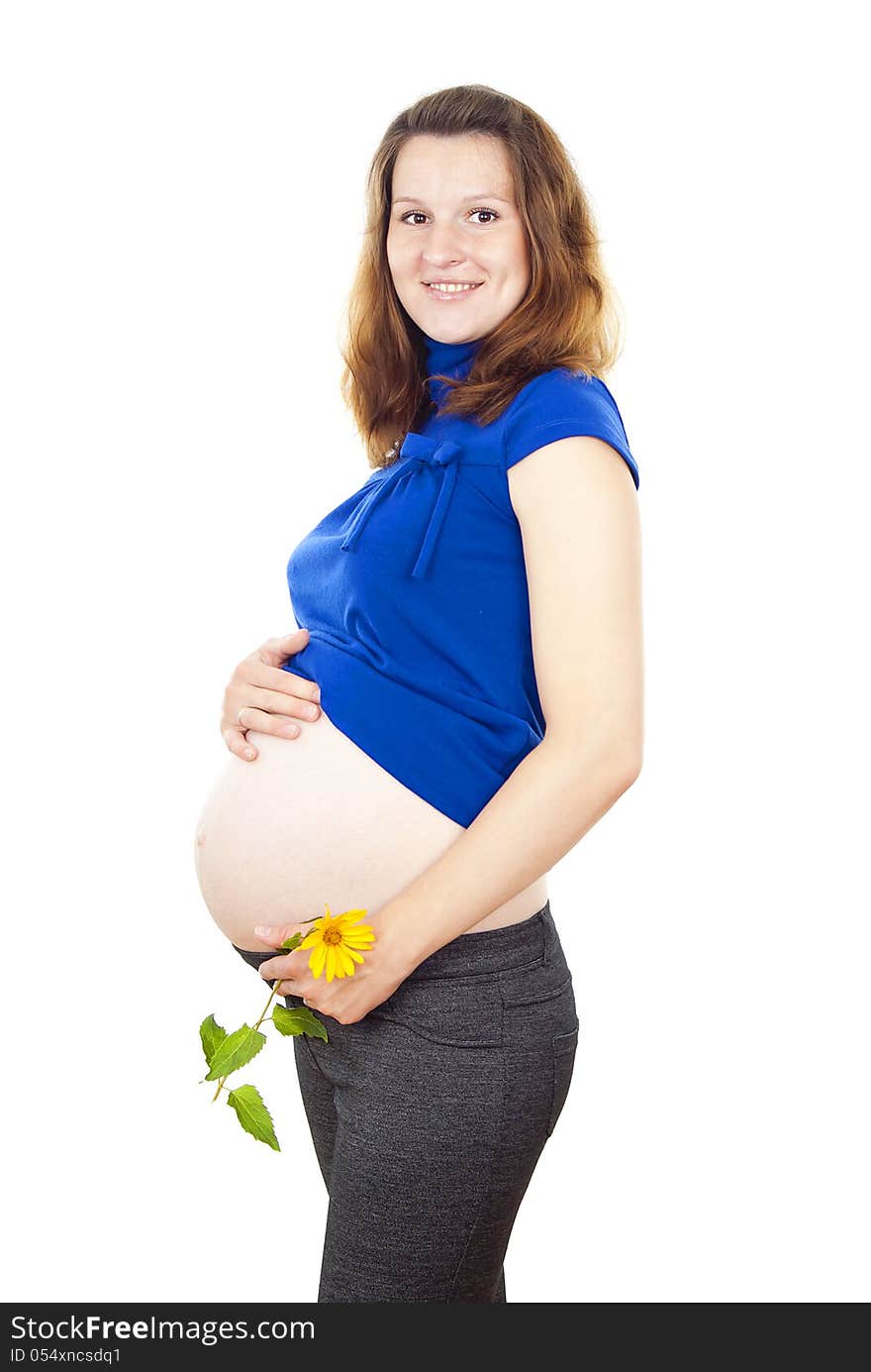 Pregnant woman stands with a flower and holding his stomach. Pregnant woman stands with a flower and holding his stomach