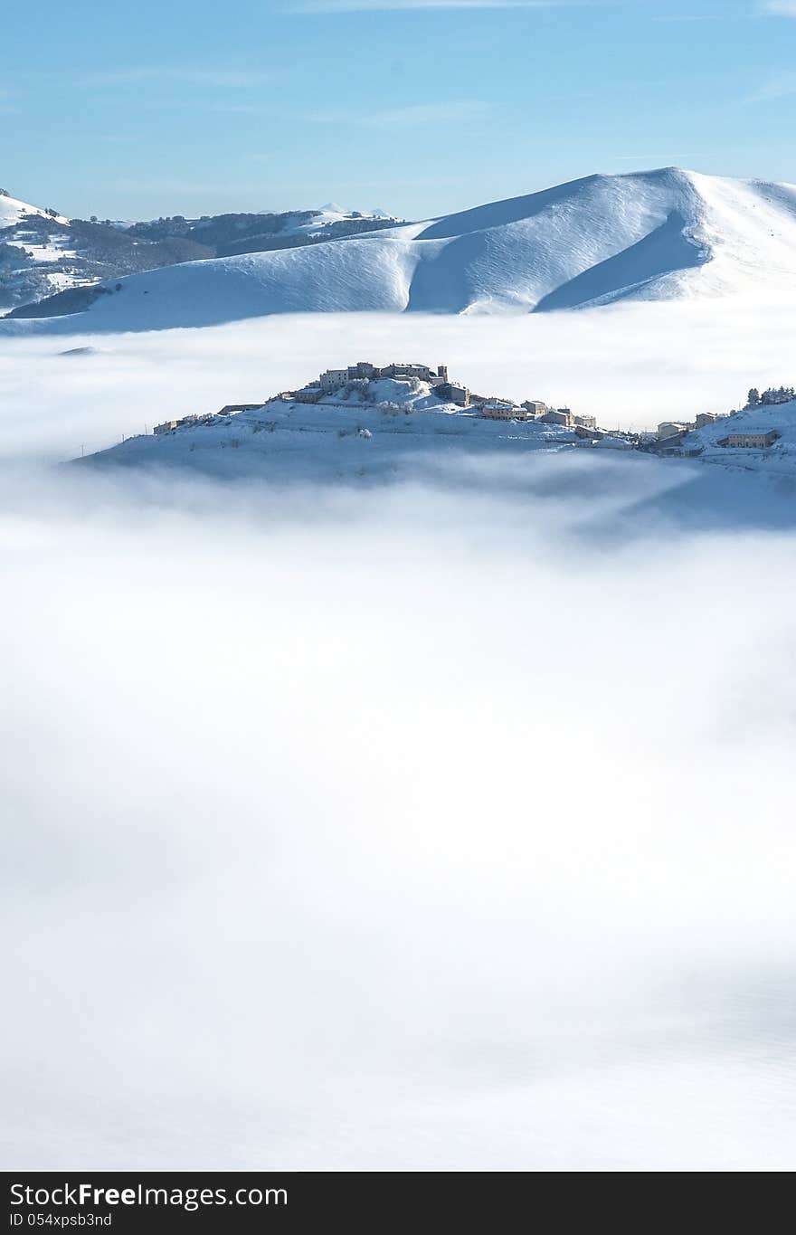 Snowy mountain above the clouds with a clear blue sky. Snowy mountain above the clouds with a clear blue sky