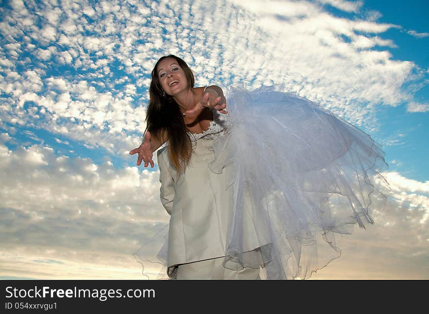 Bride in a wedding dress on a background of the blue sky. Bride in a wedding dress on a background of the blue sky.