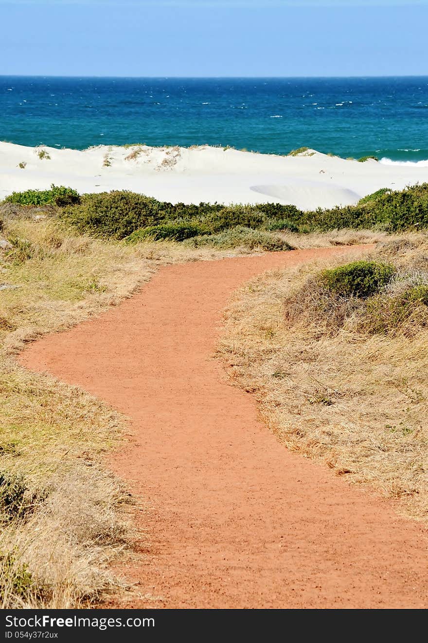 Landscape with red path leading to the beach...