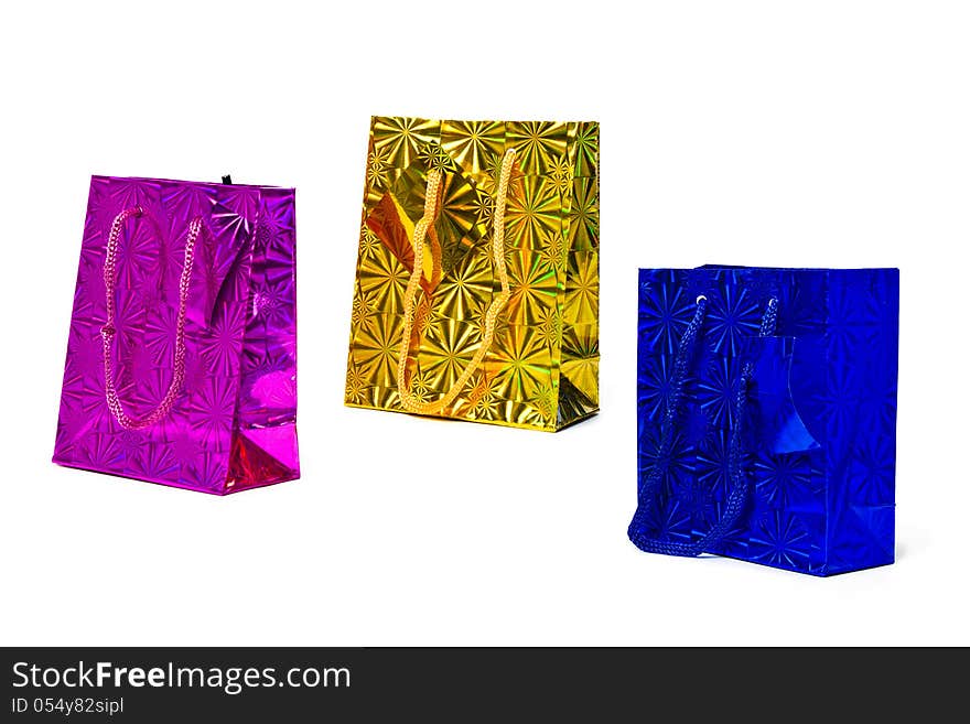 Three isolated holographic paper gift bags of magenta, gold and blue. Three isolated holographic paper gift bags of magenta, gold and blue.