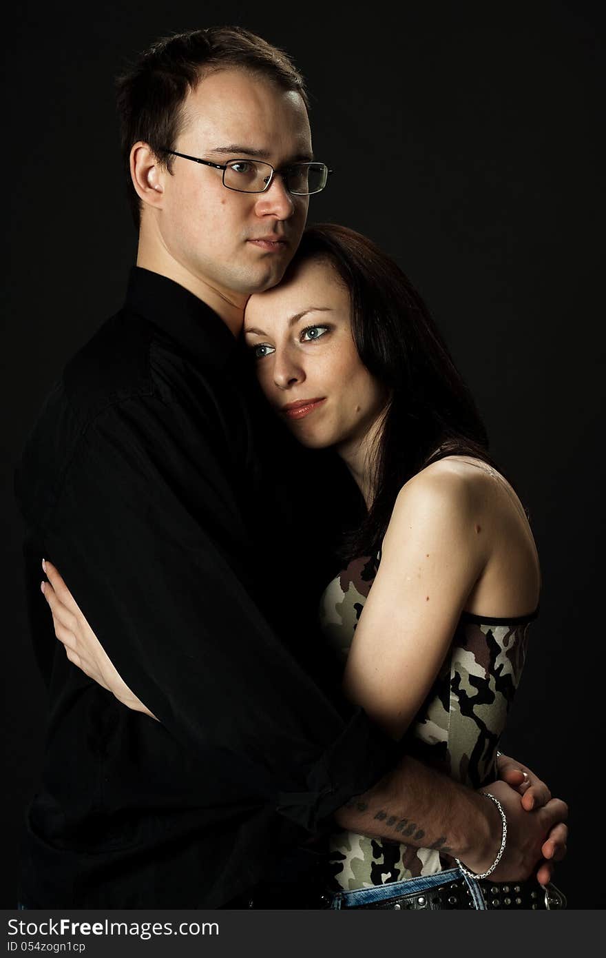 Portrait of young happy couple in studio on black background