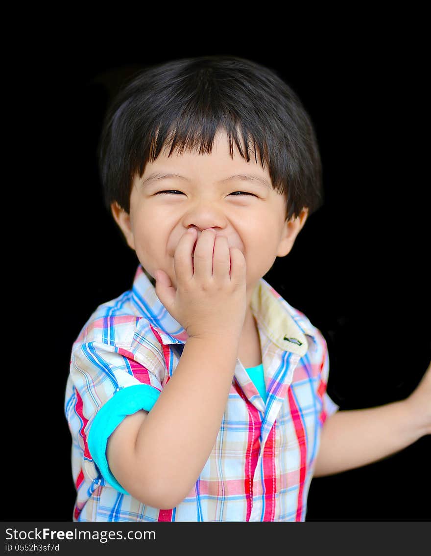 Little boy laughing with one hand in front of his mouth