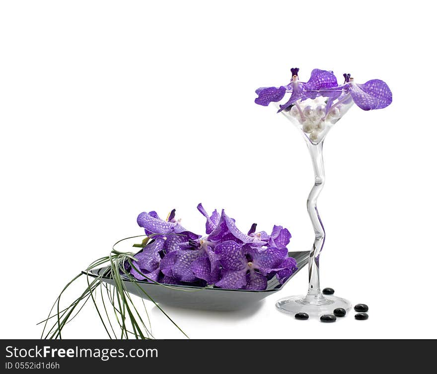 Flowers of orchid Vanda in a composition with grass stems, wineglass and plate, isolated on a white. Flowers of orchid Vanda in a composition with grass stems, wineglass and plate, isolated on a white