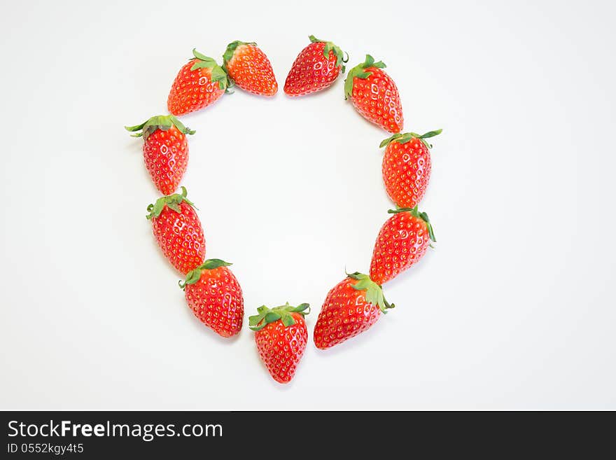 Fresh strawberry in heart shape on white background