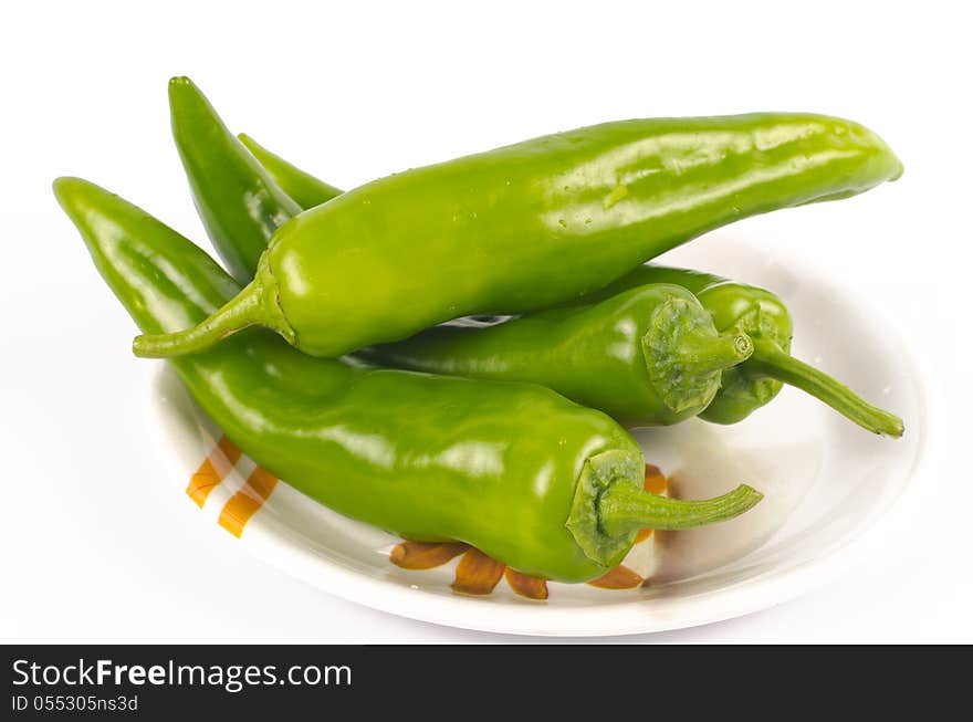 Green chilli peppers (Jalapenos) placed in a saucer on white background. Green chilli peppers (Jalapenos) placed in a saucer on white background.