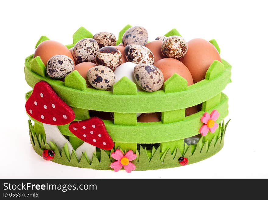 Quail eggs and chicken in green decorative basket