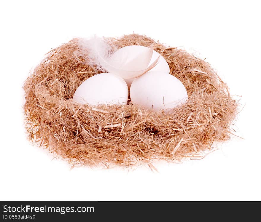 Three egg whites with a feather in the nest