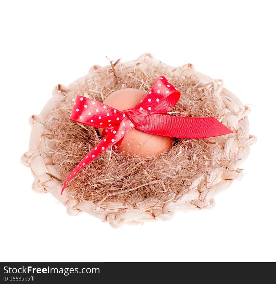 Easter egg with a red ribbon in the straw hat isolated