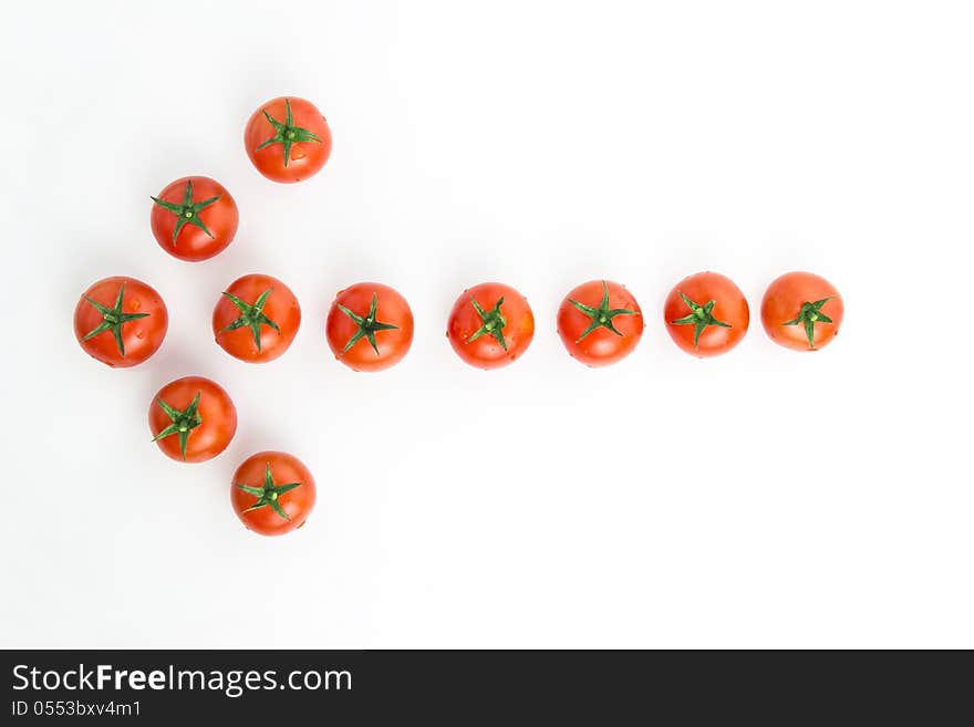 Arrow made of tomatoes over white background. Arrow made of tomatoes over white background