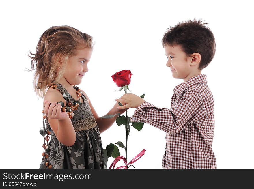 Smiley and cute children are holding a red rose and they are looking at each other. Smiley and cute children are holding a red rose and they are looking at each other