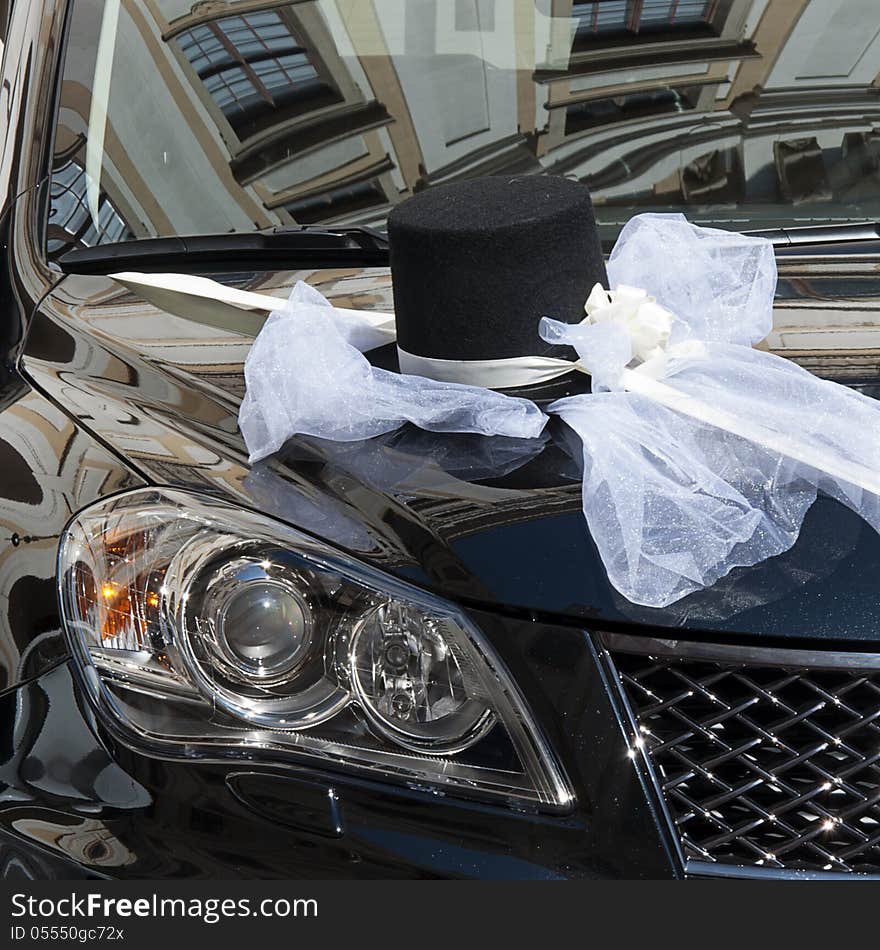 Detail of a hat and bow decoration on a black wedding car. Detail of a hat and bow decoration on a black wedding car.