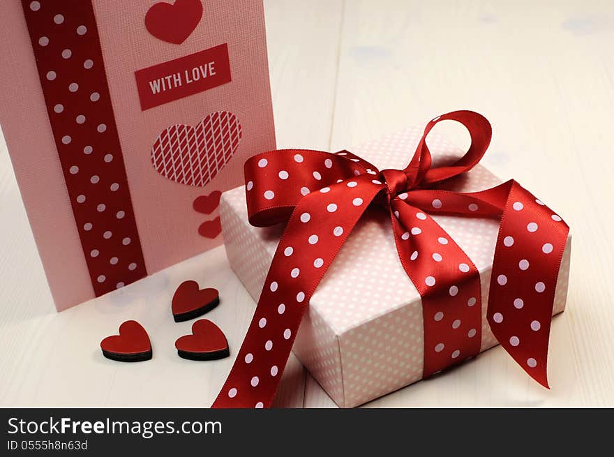 Love theme ft card with pink gift and red polka dot ribbon and hearts.