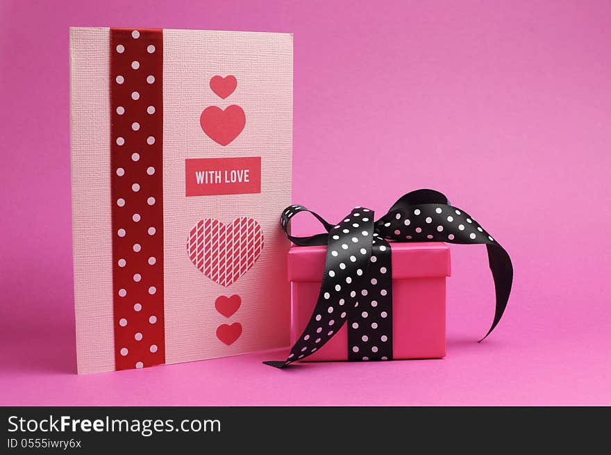 Cute handmade pink and red greeting cardand gift with polka dot ribbon and 'with love' message on a pink background. Cute handmade pink and red greeting cardand gift with polka dot ribbon and 'with love' message on a pink background.