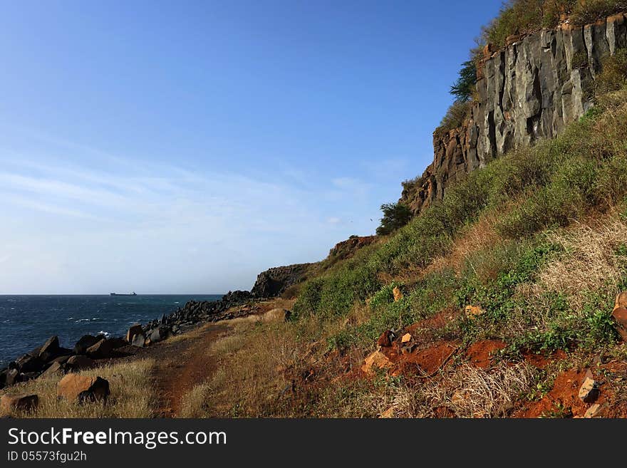 A cliff made of basaltic rocks on the oceanside. Photo taken in Senegal. A cliff made of basaltic rocks on the oceanside. Photo taken in Senegal.