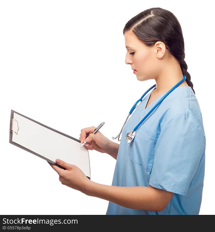 Serious young female doctor writing on clipboard, isolated on white background