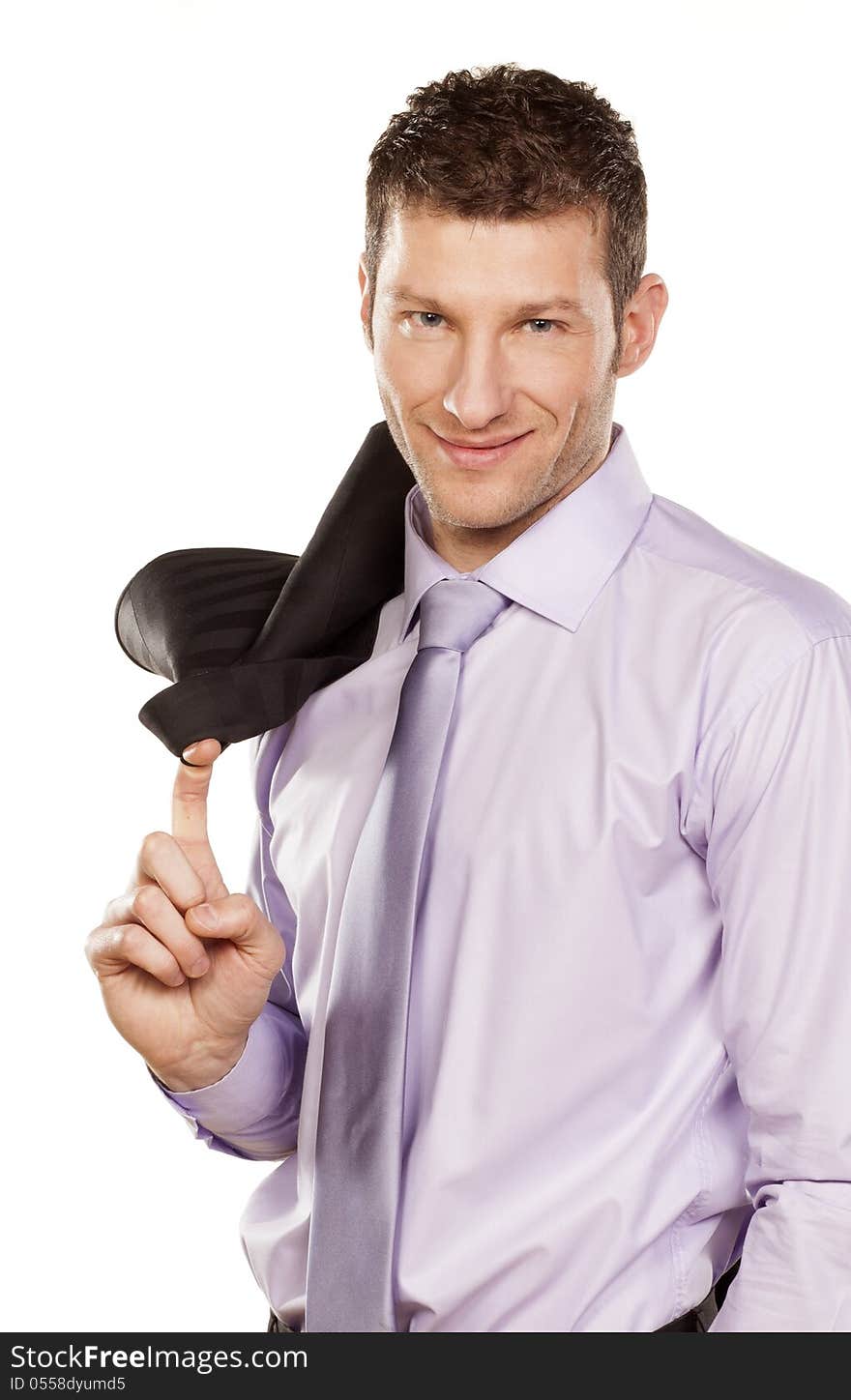 Smiling handsome businessman in a shirt with a jacket over his shoulder standing on white background