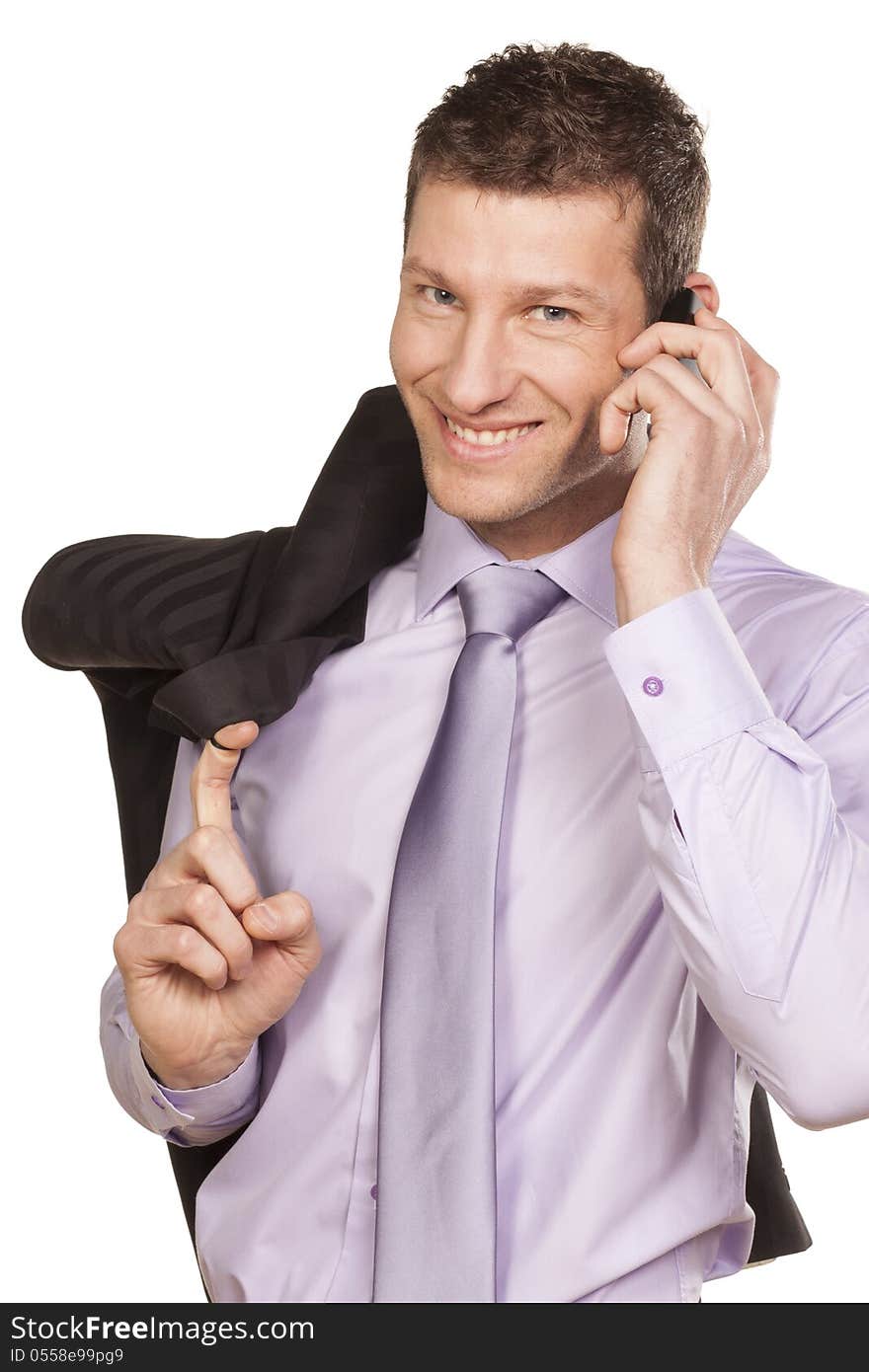 Smiling businessman with a jacket over his shoulder telephones on white background. Smiling businessman with a jacket over his shoulder telephones on white background