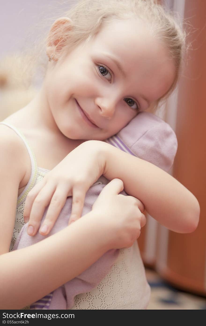 Portrait of happy little smiling girl holding toy shot indoors. Portrait of happy little smiling girl holding toy shot indoors