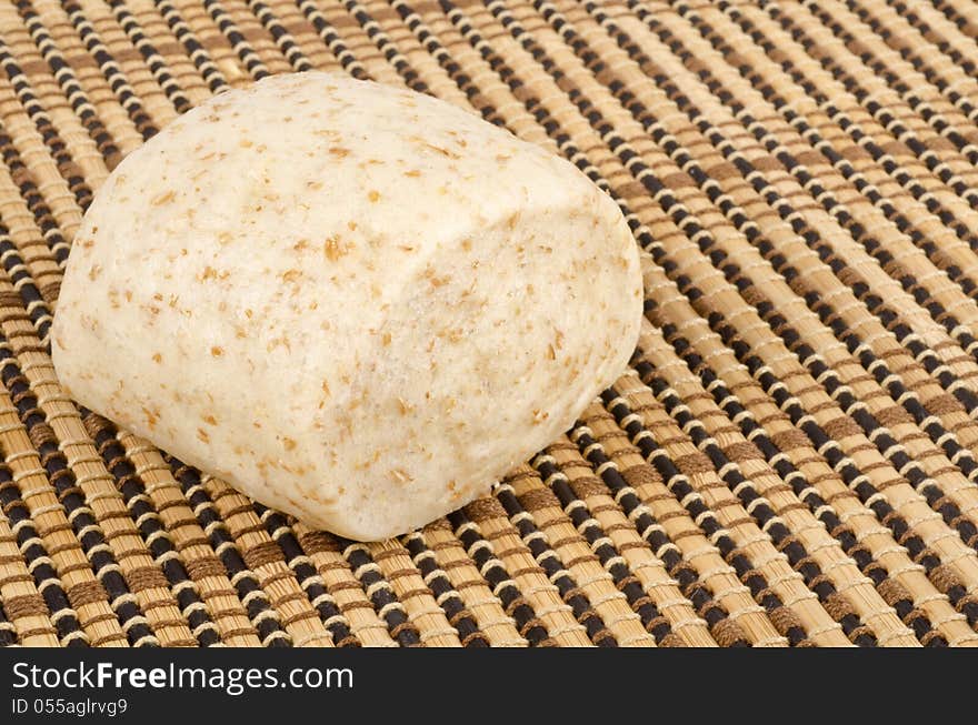 One steamed whole wheat bun on a place mat. One steamed whole wheat bun on a place mat.