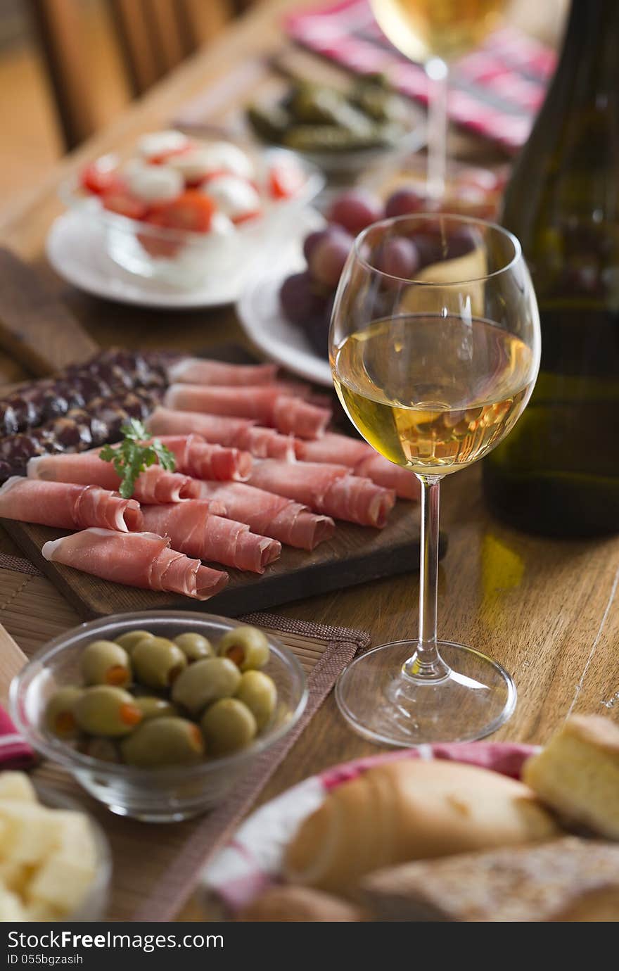 Glass of white wine on a table full with food