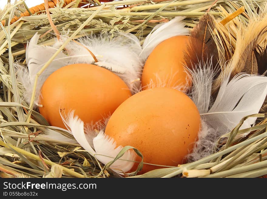 Brown eggs in wooden basket with hay and feather, food ingredient photo. Brown eggs in wooden basket with hay and feather, food ingredient photo