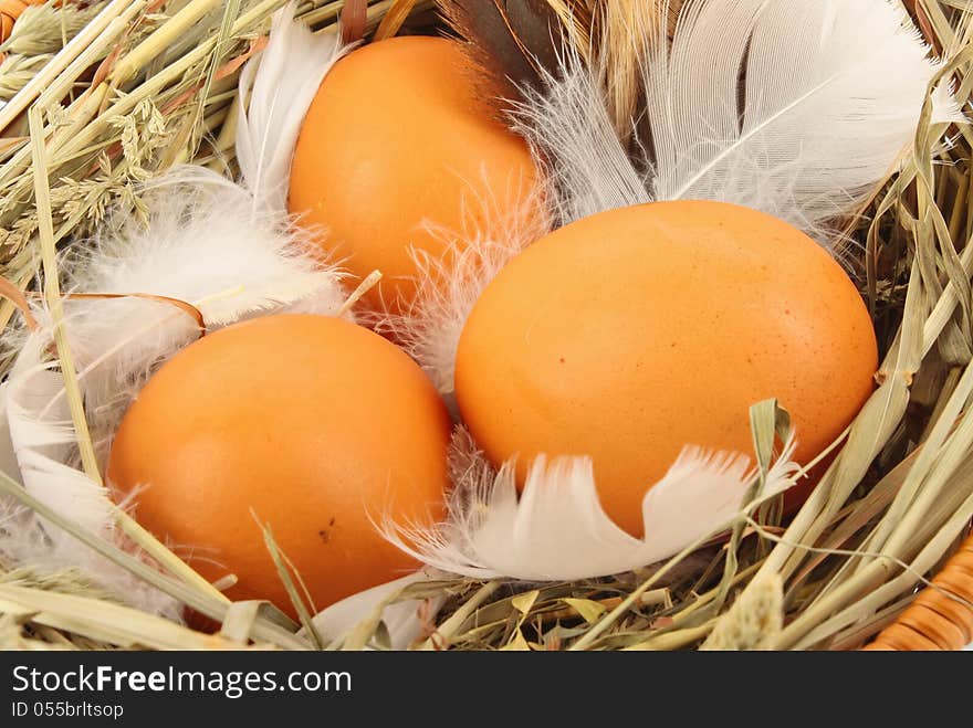 Brown eggs in wooden basket with hay and feather, food ingredient photo. Brown eggs in wooden basket with hay and feather, food ingredient photo