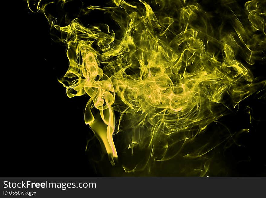 Abstract Yellow Smoke On Black Background.